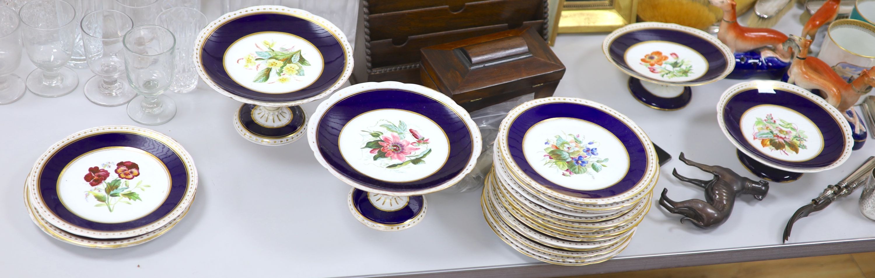 A Victorian porcelain flower painted dessert service, comprising eighteen plates and six cake stands